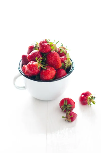 Aardbeien in wit geëmailleerd mok — Stockfoto