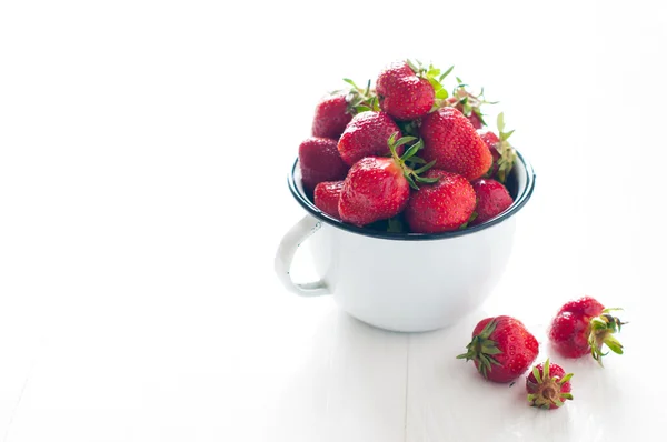 Strawberries in white enamel mug — Stock Photo, Image