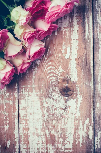 Rosas rosadas en tablero de madera viejo — Foto de Stock