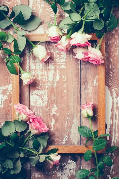 Rosas rosadas y un marco de madera — Foto de Stock