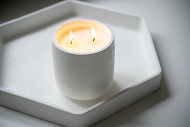 İki fitili yanan mum, beyaz kavanozda el yapımı mum.