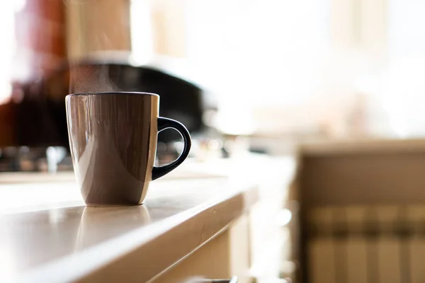 Braune Kaffeetasse auf Küchentisch mit echtem Tageslicht und Dampf — Stockfoto