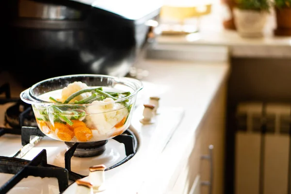 Прозора скляна сковорода з овочевим супом, свіжа гаряча їжа кипить на плиті — стокове фото
