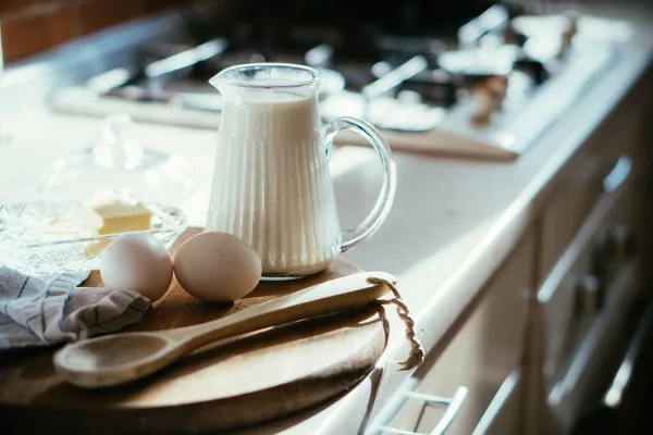 Tahtadaki taze süt ve yumurta. Gerçek ev mutfağında. İçi doğal ışıkla dolu. — Stok fotoğraf