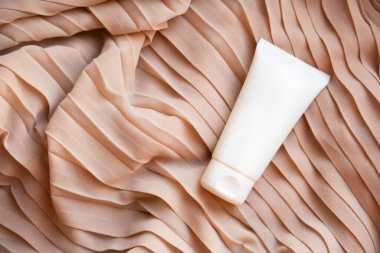 Tekstil arka planında beyaz krem tüp modeli