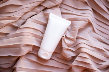 Tekstil arka planında beyaz krem tüp modeli