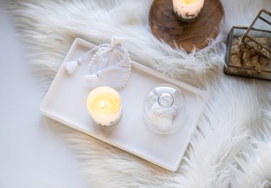 Sahte kürk battaniyeli rahat ev dekorasyonu, yanan mumlar ve iç dekorasyonlar.