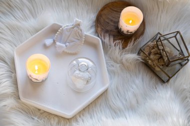 Sahte kürk battaniyeli rahat ev dekorasyonu, yanan mumlar ve iç dekorasyonlar.