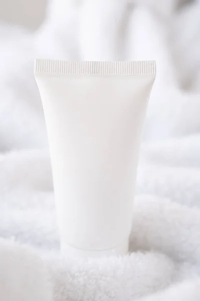 Limpe o tubo de creme cosmético branco no fundo de toalha de algodão branco fofo, mock-up e design pronto — Fotografia de Stock
