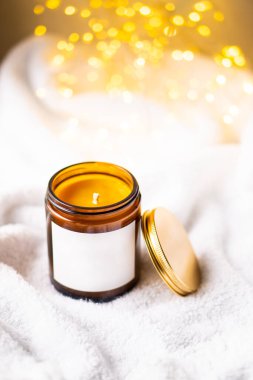 Kahverengi cam kavanozdaki doğal mum metal kapaklı ve beyaz boş çıkartmalı.