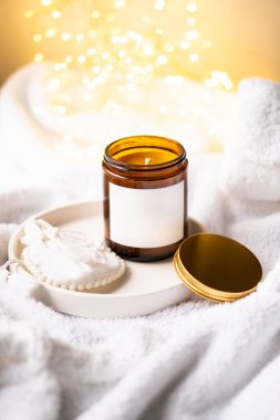 Kahverengi cam kavanozdaki doğal mum metal kapaklı ve beyaz boş çıkartmalı.