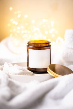 Kahverengi cam kavanozdaki doğal mum metal kapaklı ve beyaz boş çıkartmalı.