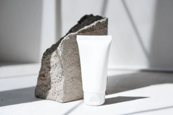 Limpe o tubo de creme branco com sombras na moda e textura de pedra — Fotografia de Stock