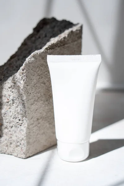 Limpe o tubo de creme branco com sombras na moda e textura de pedra — Fotografia de Stock