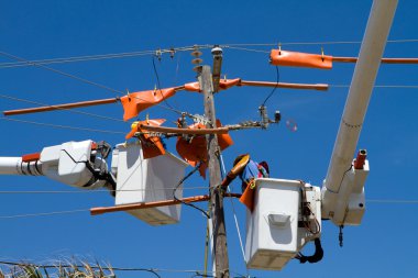 elektrik hatları üzerinde çalışıyor