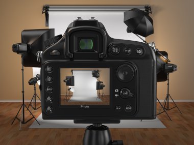 Digital photo camera in studio with softbox and flashes