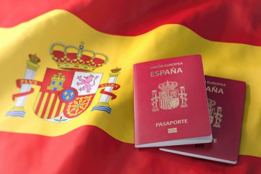 İspanya pasaportu İspanyol bayrağında. Vatandaşlık, göç, seyahat ve turizm konsepti. 3d illüstrasyon