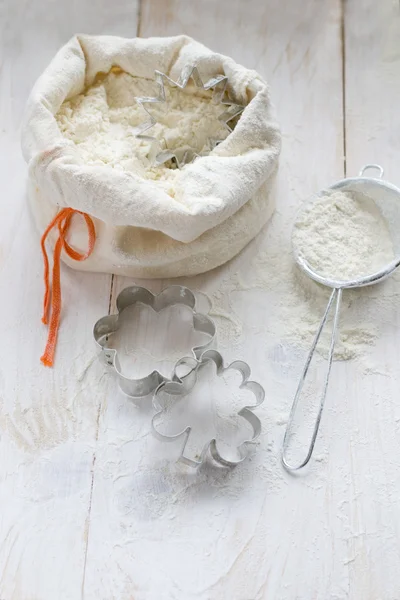 Saco com farinha e cortador de biscoitos — Fotografia de Stock