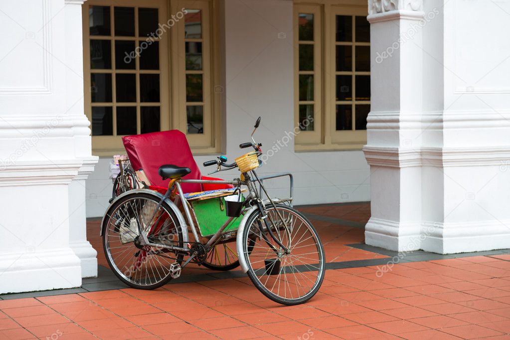Empty bicycle rickshaw near classical colonial building