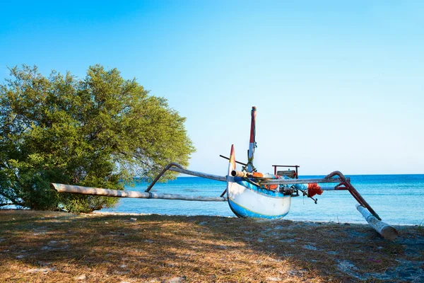 Barco tradicional indonesio en la playa con mar azul — Foto de Stock