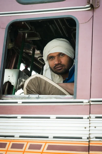 Motorista indiano em turbante branco na cabine de seu caminhão — Fotografia de Stock
