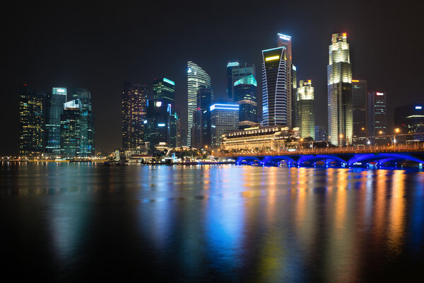 Night illuminated skyline view with water reflections, Singapore