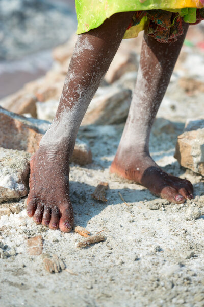 Worker feet salt in salt farm