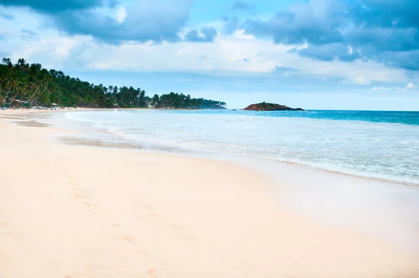 Bulutlu karanlık mavi gökyüzü ile tropikal plaj — Stok fotoğraf