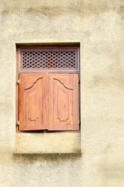 Sarı duvar üzerinde küçük ahşap klasik pencere