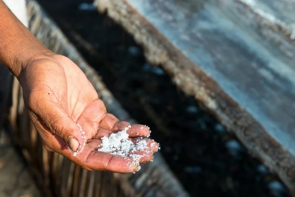 Mannelijke werknemer hand met vers uitgepakte zeezout in bali, indone — Stockfoto