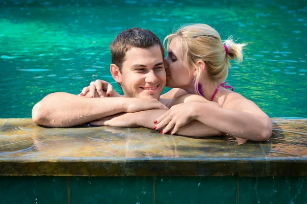 Kissing and relaxing in a swimming pool — Stock Photo, Image