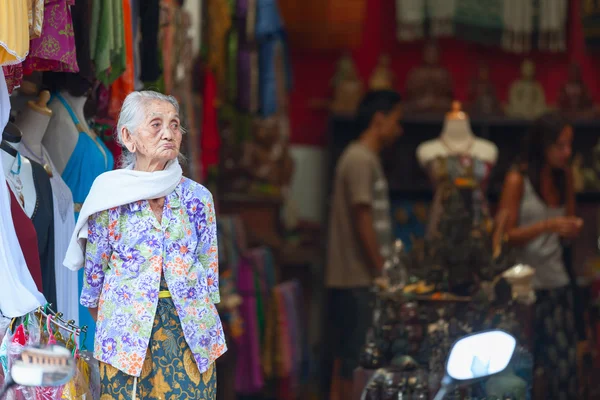Old balinese woman near souvenir shop in Ubud — Stock Photo, Image