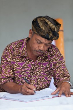 Balinese man maintain records in register book clipart