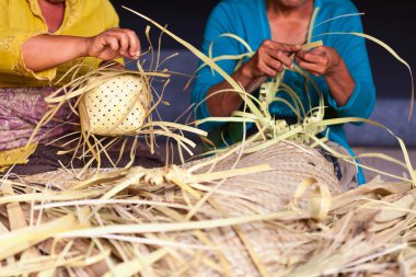 Balinese women make baskets for offerings clipart