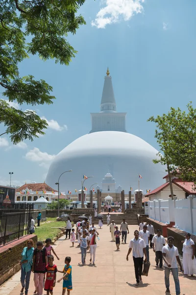 白い神聖な仏舎利塔、アヌラーダプラ、スリランカの近くの巡礼者 — ストック写真