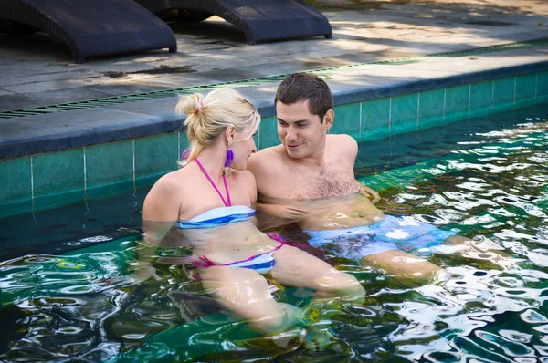 スイミング プールで幸せな笑みを浮かべてカップル — ストック写真