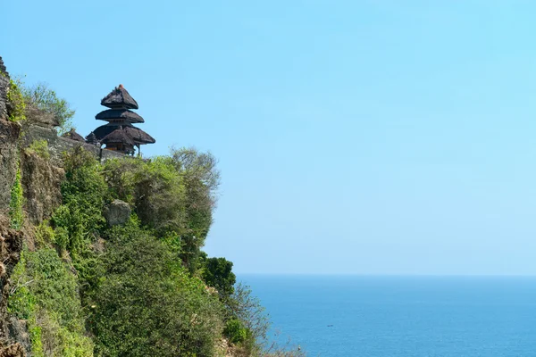 Temple balinais sur la roche au-dessus de la mer tropicale bleue — Photo