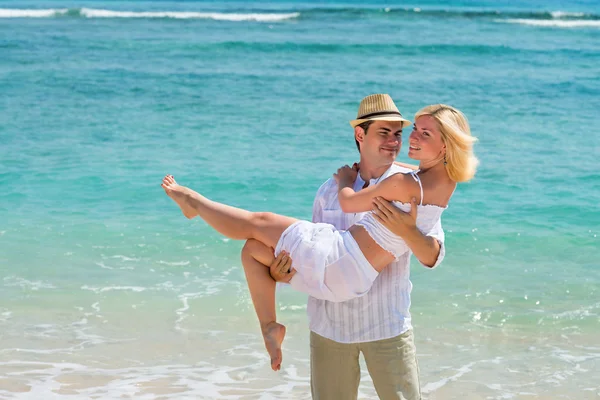 Glückliches junges Paar genießt am Strand — Stockfoto