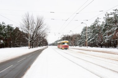 Kırmızı ve sarı tramvay bir kar kış yolda