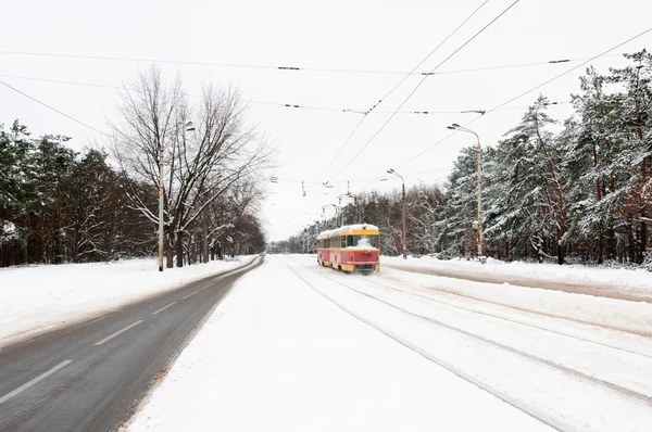 Red and yellow tram on a snow winter road — Stock Photo, Image