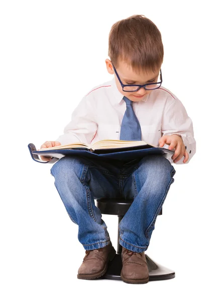 Lindo niño inteligente en gafas leer libro de notas —  Fotos de Stock