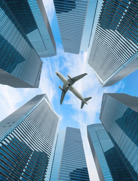 Modern şehir üzerinde beyaz bir uçak fly — Stok fotoğraf