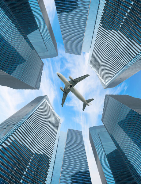 White airplane fly above modern city