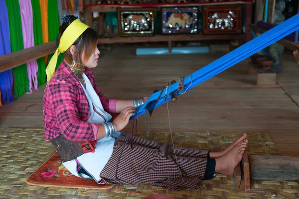 Женщина с длинной шеей Каян Лахви плетет на традиционном устройстве — стоковое фото