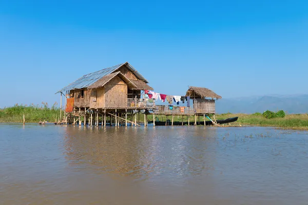 Casa de stilts tradicional em água abaixo do céu azul — Fotografia de Stock
