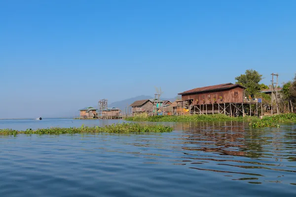 푸른 하늘 아래 물에 전통적인 죽 마 집 — 스톡 사진