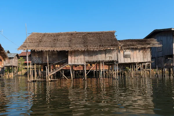 Traditionella styltor house i vatten under blå himmel — Stockfoto