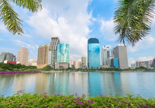 Cidade moderna tropical com palmeiras e lago em frente — Fotografia de Stock