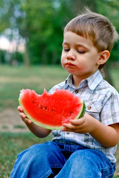 Kaukasiska liten pojke äter en skiva vattenmelon — Stockfoto