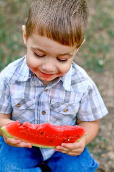 Kaukasiska liten pojke äter en skiva vattenmelon — Stockfoto